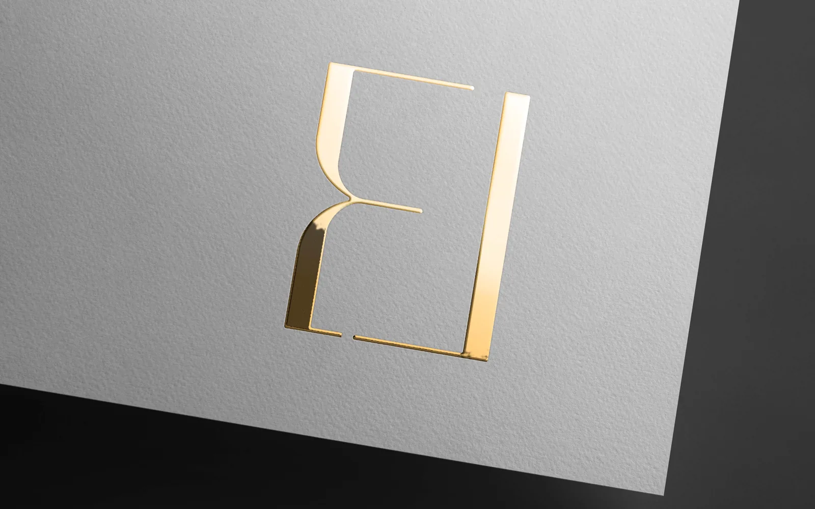 Embossed gold E&L monogram on a dark surface