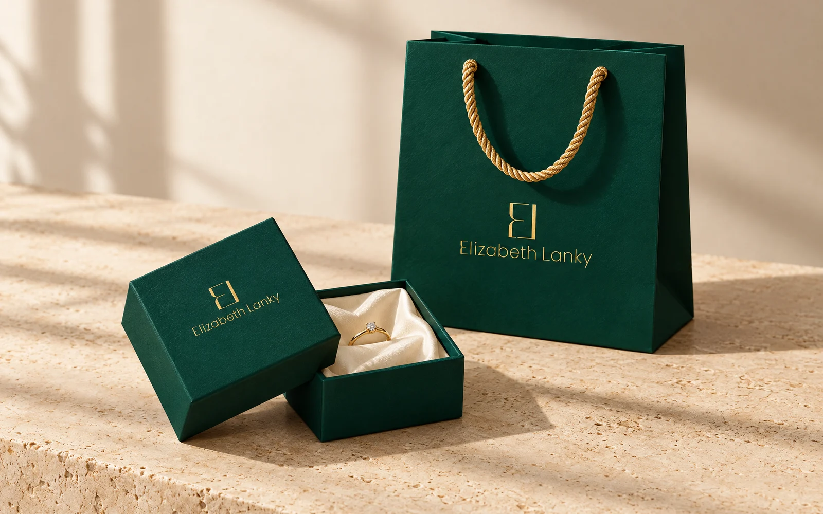 Elizabeth & Lanky brand identity by Mike Bruce Design: emerald jewellery box and shopping bag with the gold monogram