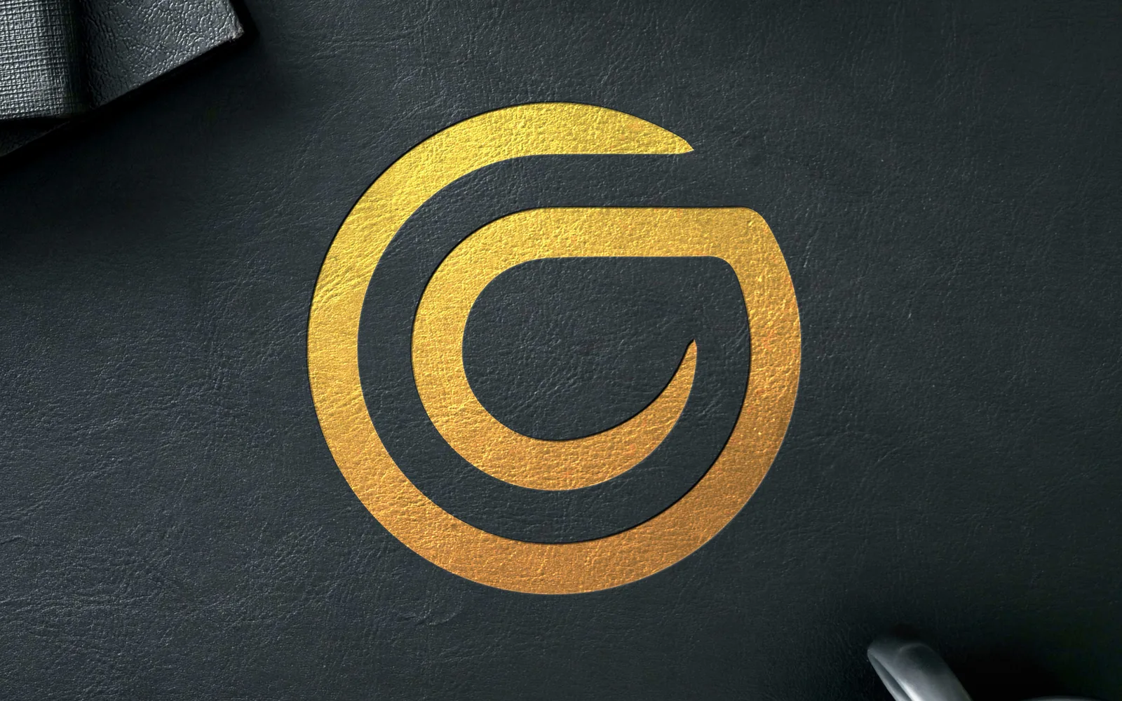 Gazellos G icon in gold foil on a dark textured surface